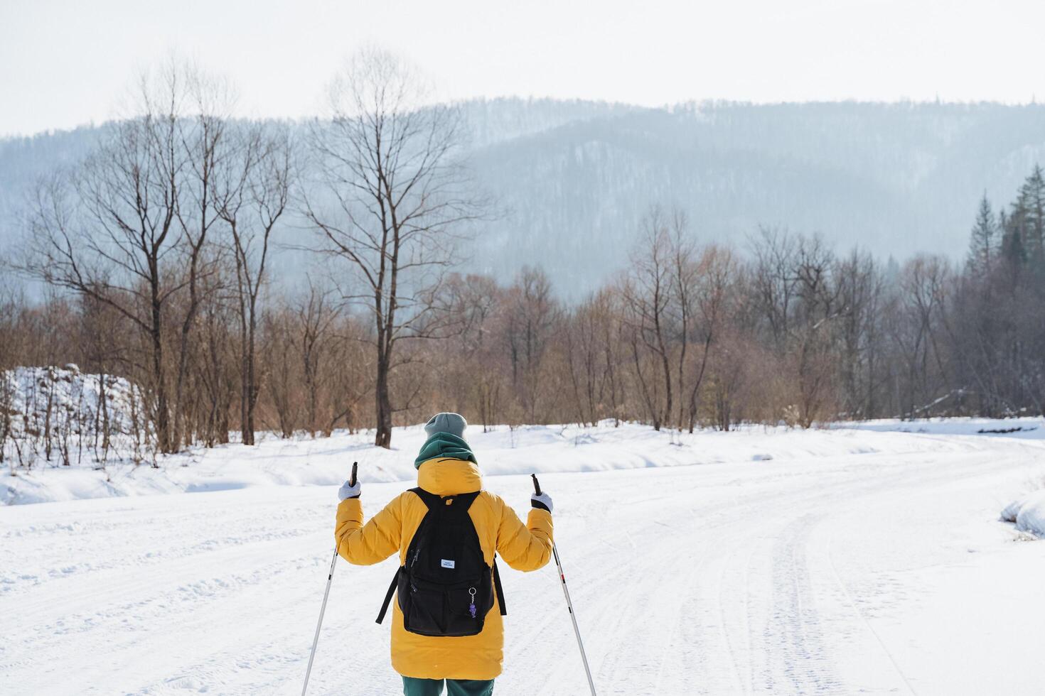 A skilled skier glides gracefully through a breathtaking snowy landscape, effortlessly navigating through pristine, unblemished snow while delighting in the refreshing, crisp winter air photo