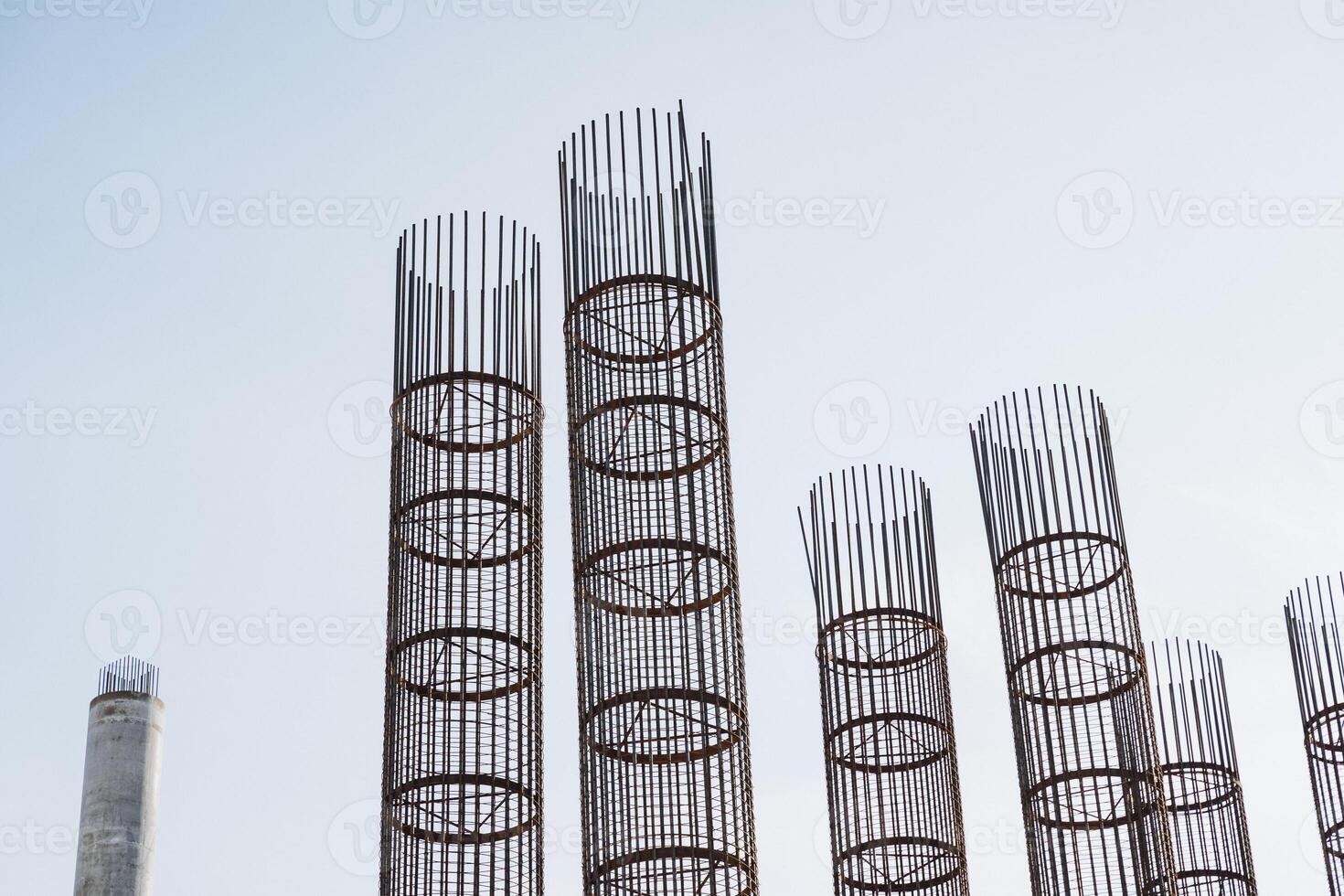 A long row of shiny metal pipes stands out vividly against a clear blue sky, showcasing the industrial beauty and functionality of these cylindrical structures made of various metals photo
