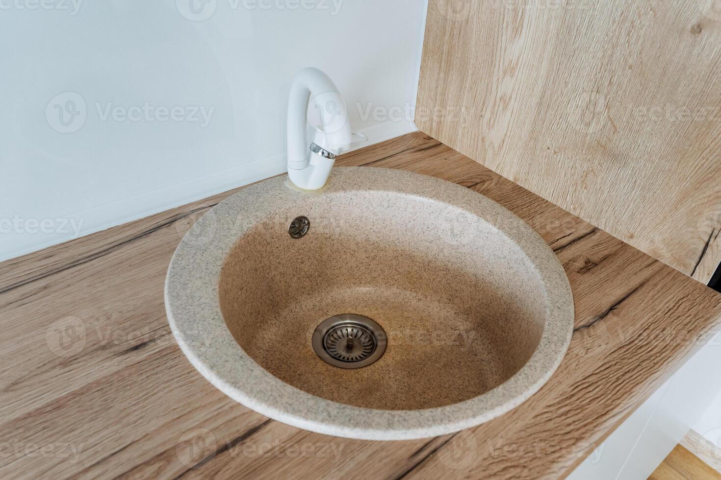 A beautifully crafted round sink is elegantly positioned atop a beautifully polished wooden counter, showcasing a perfect blend of style, sophistication, and functionality for any space photo