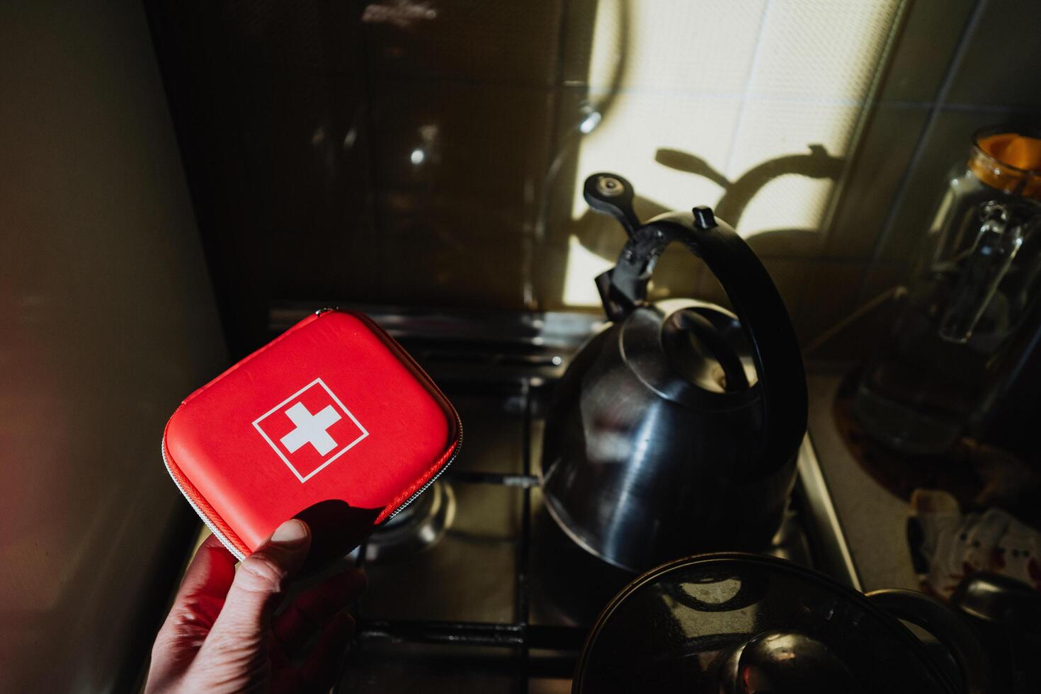 A First Aid Kit alongside a Kettle, set within a Cozy Kitchen, exemplifies the essential balance of safety and comfort necessary for everyday living and cooking tasks photo
