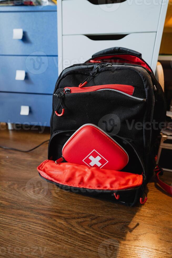 This trendy black and red backpack boasts a builtin first aid kit, making it perfect for emergency preparedness and outdoor activities such as hiking, camping, or travelling photo