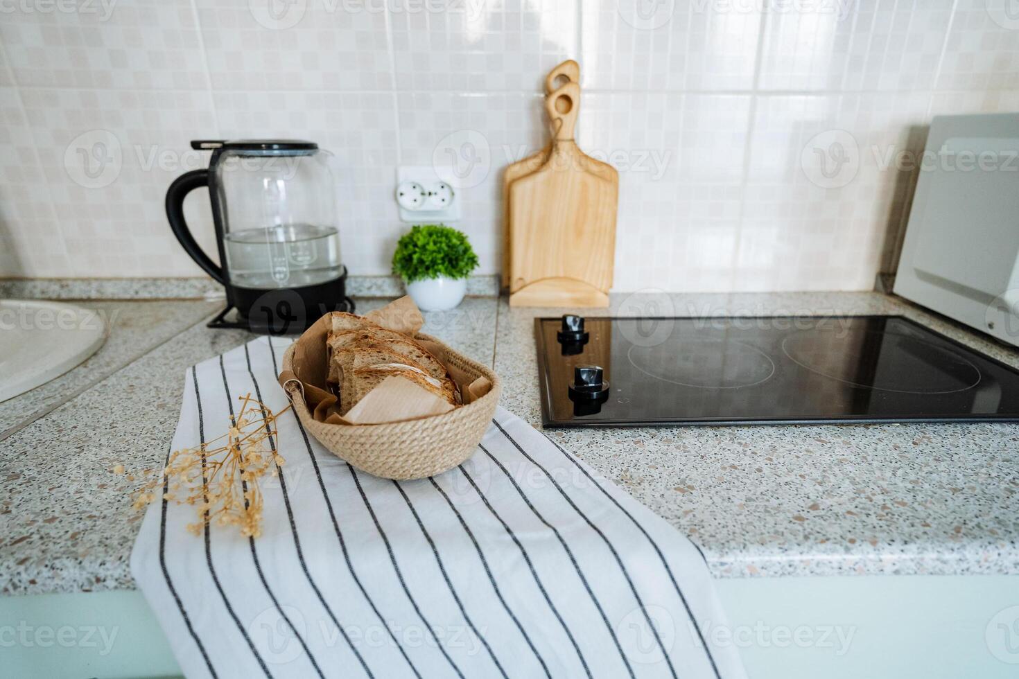 A bowl full of freshly baked bread is placed carefully on a striped towel that is spread out on the kitchen counter, adding a touch of warmth and coziness to the overall kitchen ambiance photo