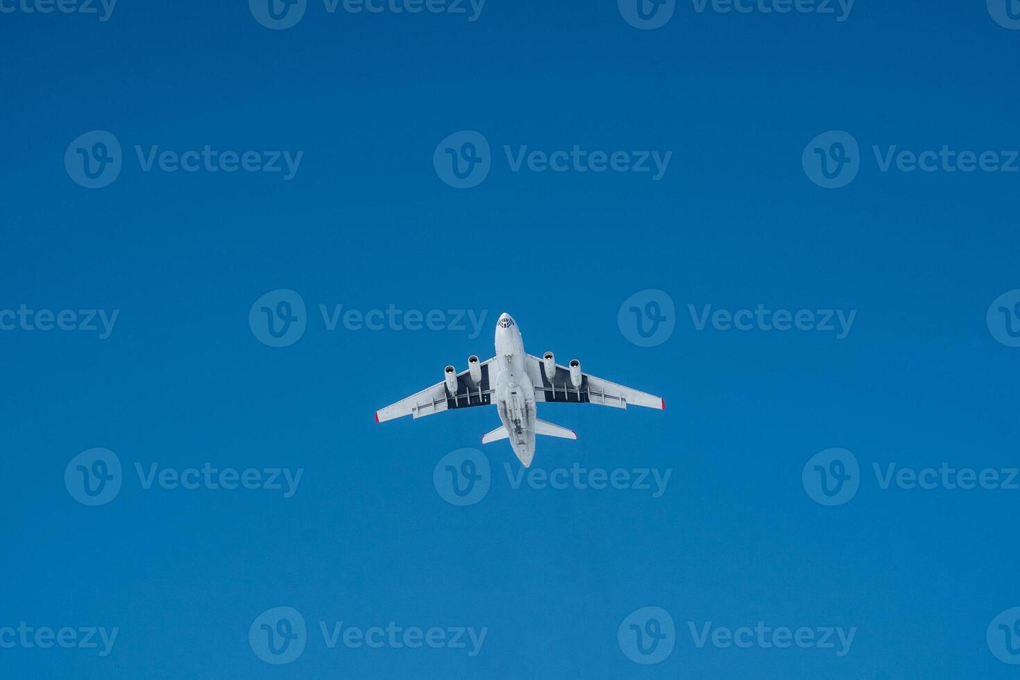 A bright white airplane is soaring gracefully through a beautifully clear blue sky on a lovely, sunny day, showcasing the wonders of aviation and air travel. Its a magnificent sight photo
