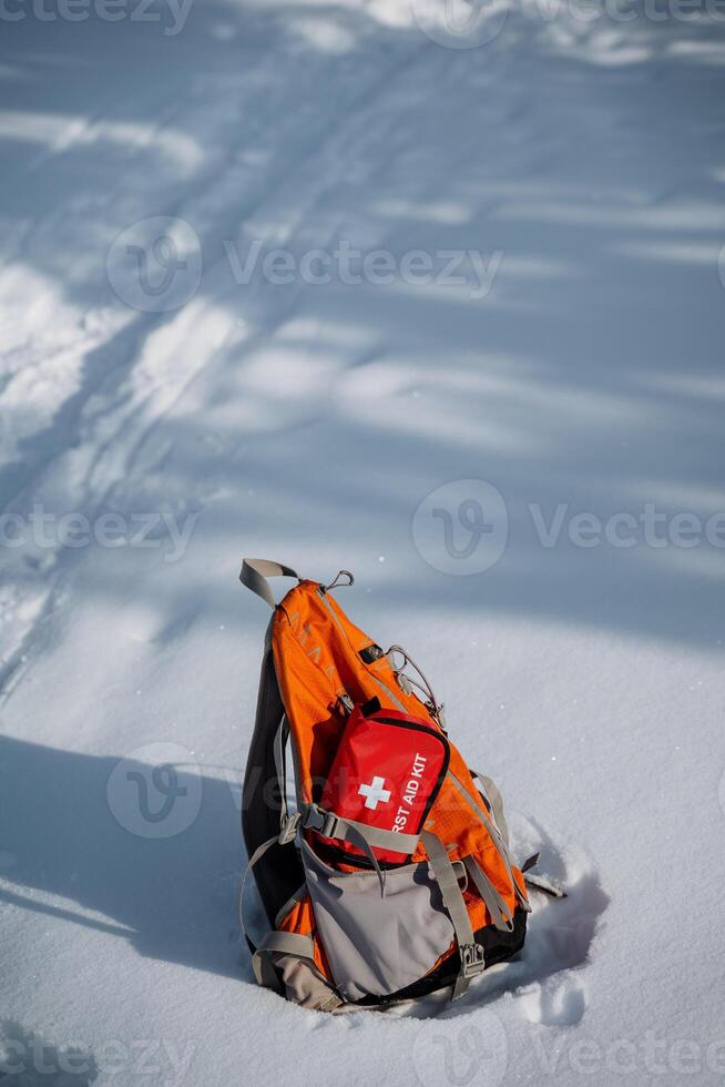 A durable backpack with a first aid kit is shown in a snowy scene, showcasing essential gear for winter adventures and ensuring safety during cold hikes in tough weather photo