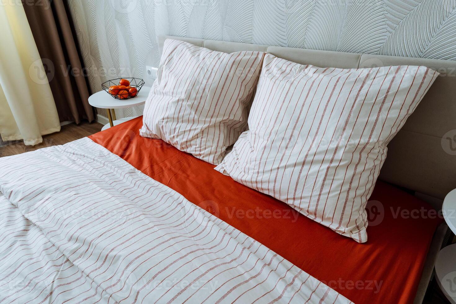 In a beautifully decorated bedroom, there is a cozy bed adorned with striped sheets and soft pillows, creating a welcoming and comfortable atmosphere for rest and relaxation photo