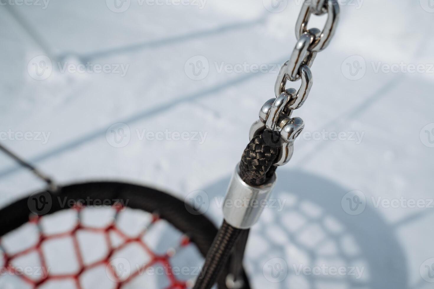 A CloseUp View of the Swing Chain Attachment in a Playground Covered with Snow, Highlighting its Design and Functionality for Childrens Play and Recreation in Winter photo