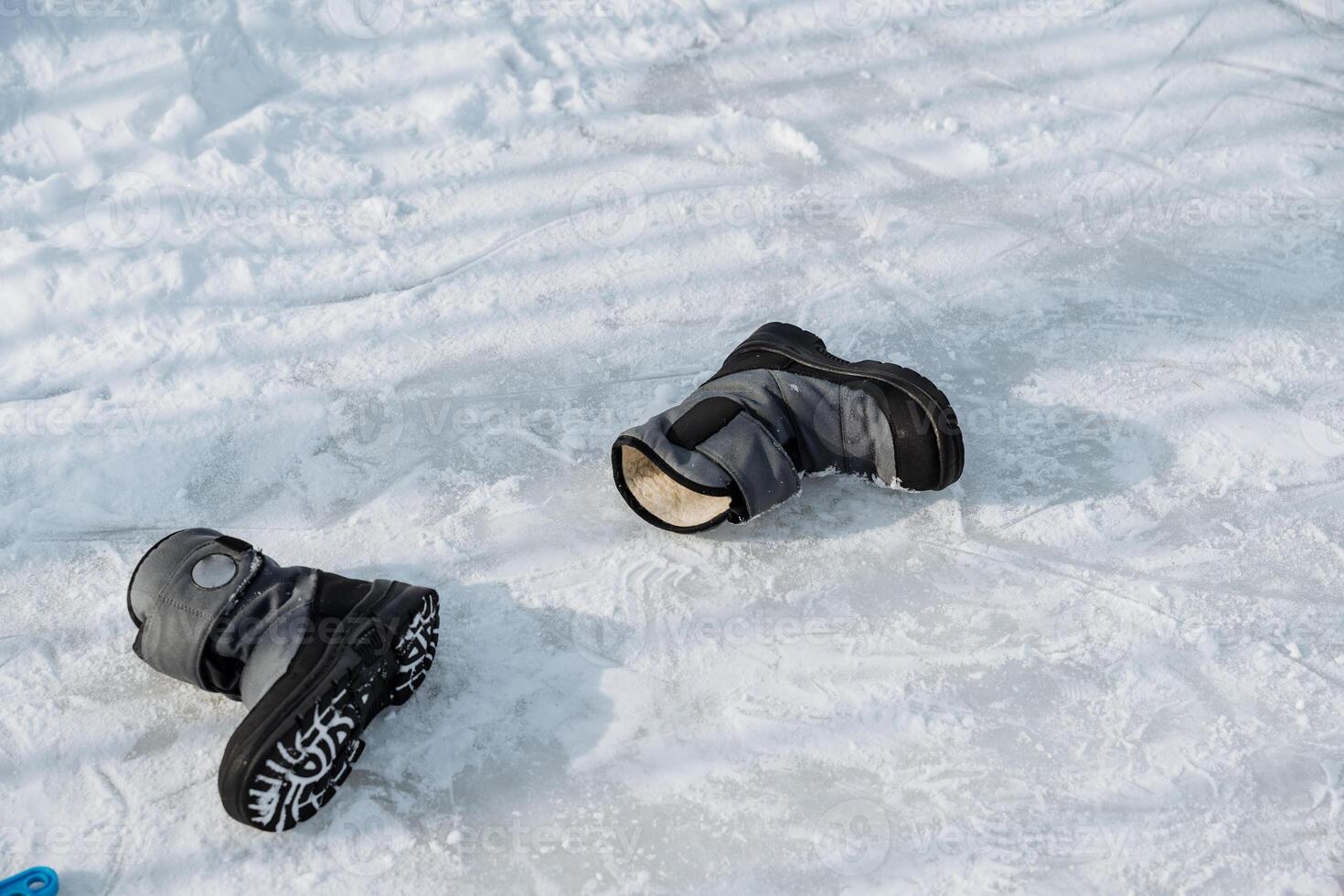 Abandoned Winter Boots Left on the Snowy Ground are a Strong Representation of Adventure and the Activities Associated with Cold Weather Usages Such as Skiing or Hiking photo
