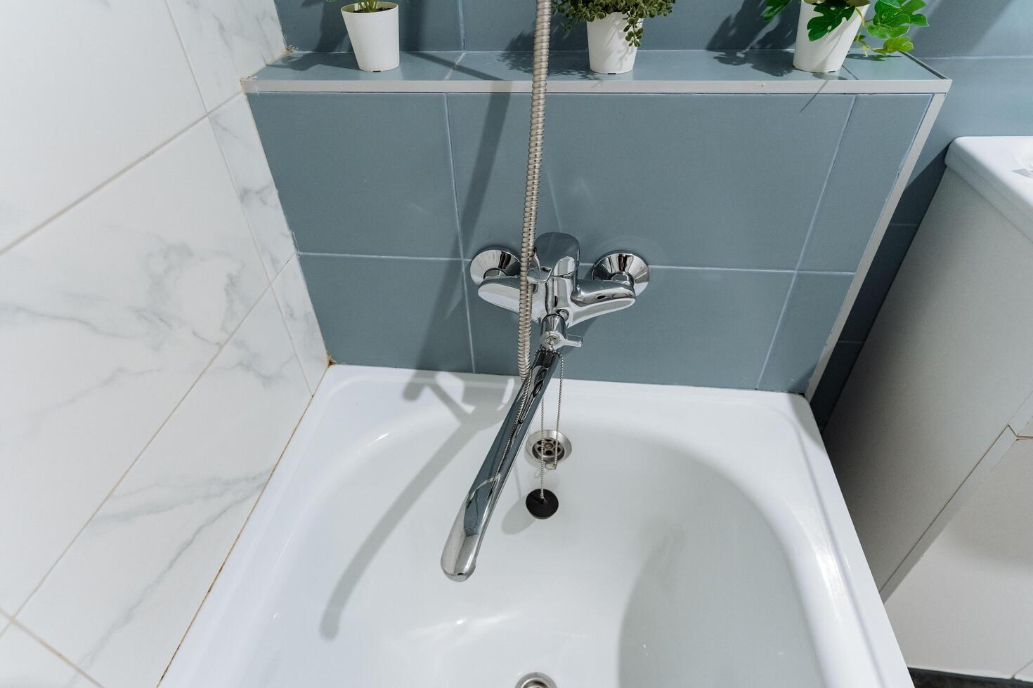 A spacious bathroom featuring both a comfortable bathtub for relaxation and a functional faucet for convenience and easy access to water, making it a practical and stylish space photo