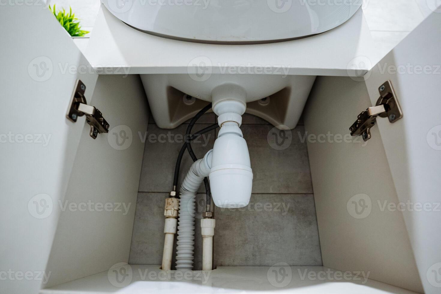 The open cabinet under the bathroom sink allows maintenance personnel easy access to the plumbing system for checks, inspections, and identifying potential future issues photo