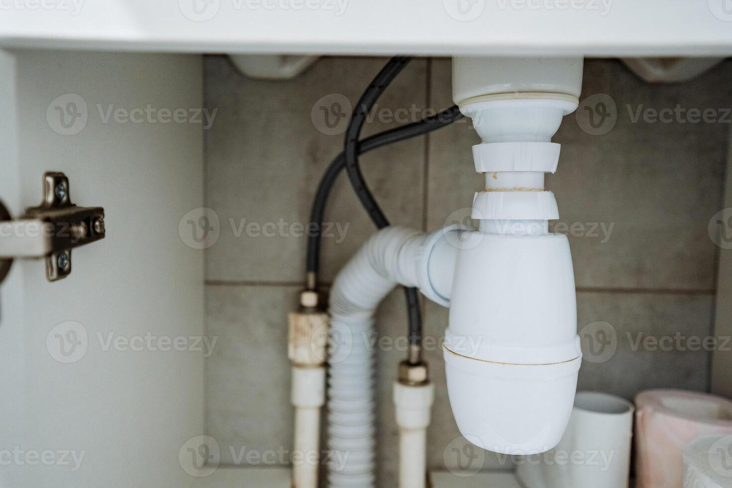In a typical bathroom environment, you can find a sink that has a drain pipe placed directly underneath it, enabling the effective and proper disposal of wastewater following usage photo