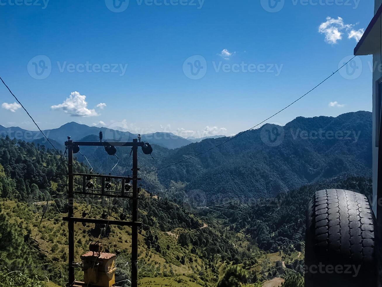 A magnificent and majestic mountain range soars high against the clear blue sky, while an old, solitary tire intriguing in nature adds an interesting perspective to this stunning landscape photo