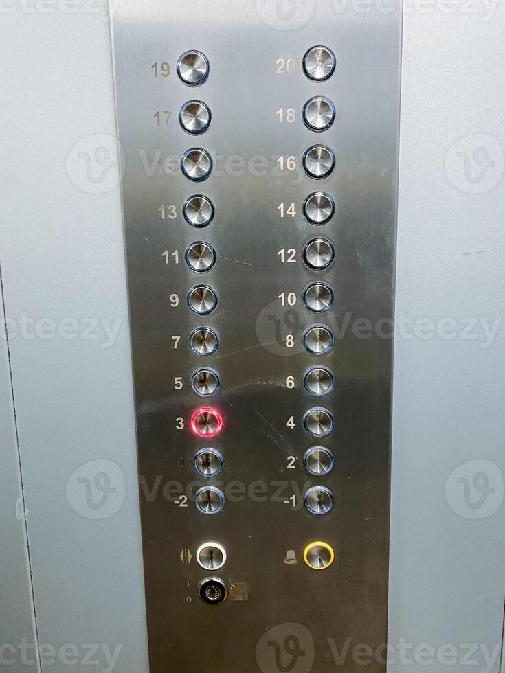 This image features a closeup view of a stainless steel elevator control panel, showcasing its modern design and technological features, emphasizing its sleek and shiny silver finish photo
