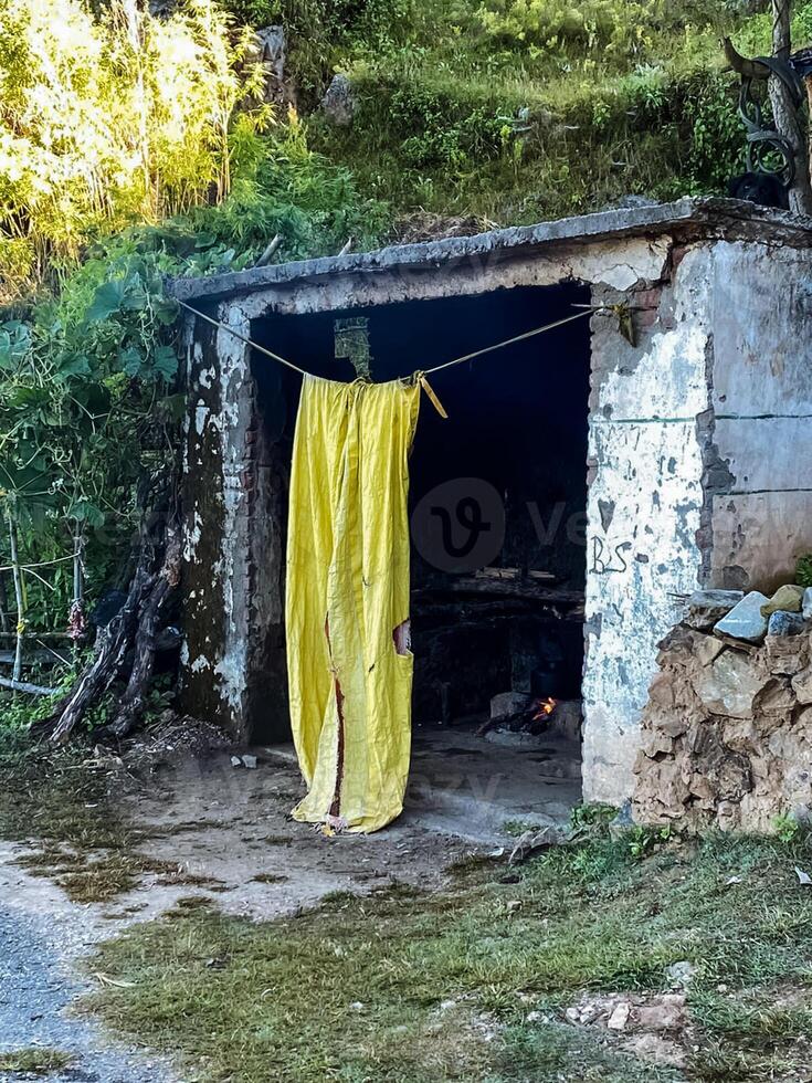 A vibrant yellow cloth is currently hanging out on a clothes line in an outdoor setting adjacent to a building, where it catches the eye with its bright color and uniqueness photo