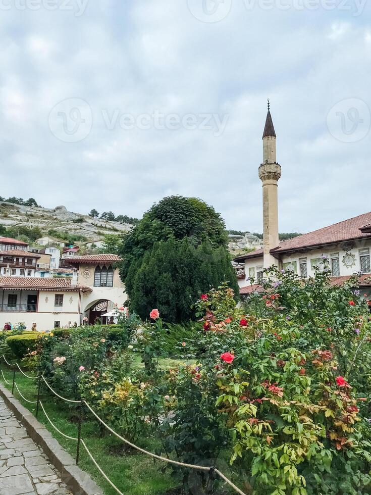 In the center of a beautiful garden, there stands a mosque complete with an impressive tower that majestically rises into the sky, offering a serene and peaceful atmosphere photo
