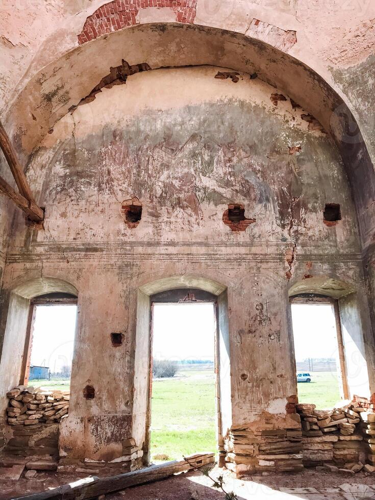 In the distance, a very old and historic building stands tall, adorned with a myriad of windows, while a sprawling field stretches out in the background, enhancing its timeless beauty photo