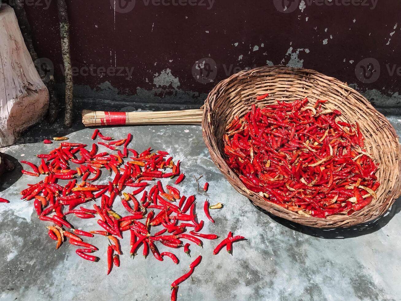 A beautifully crafted wicker basket overflows with vibrant red peppers, arranged neatly to showcase their rich color and unique texture, making them irresistibly appealing photo