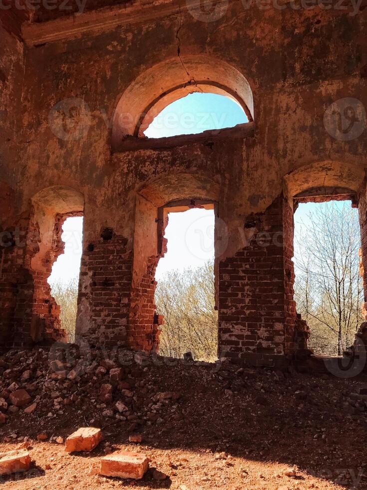A dilapidated building stands proudly despite its worn condition, featuring a unique and striking central window that hints at its remarkable architectural past and rich, storied history photo