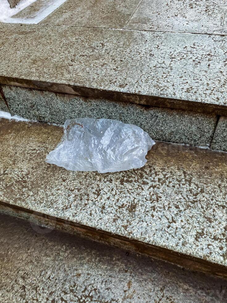 A plastic shopping bag is resting on a staircase made of concrete, marble, or granite, drawing attention to the distinctive architectural features of the building surrounding it photo