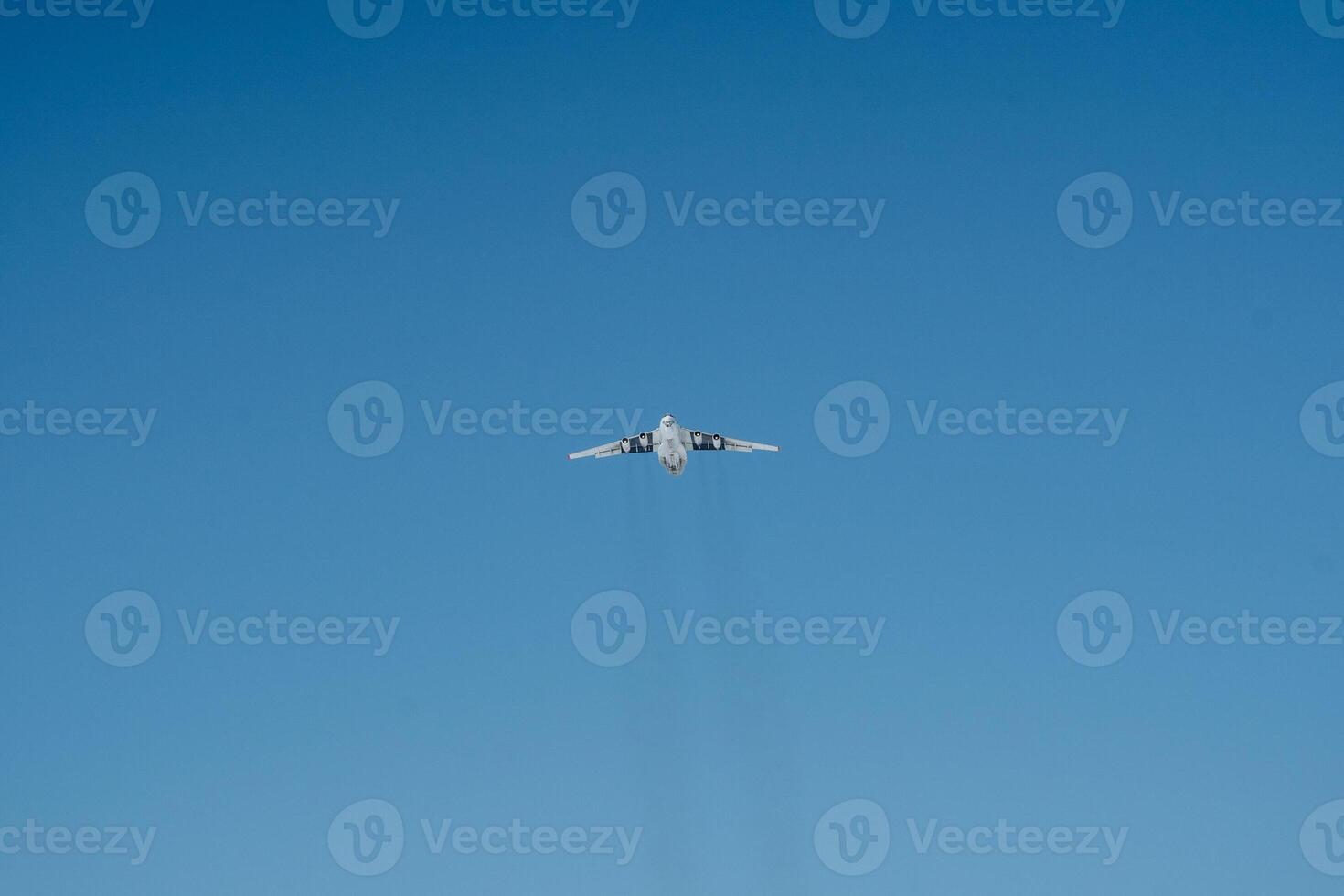 A plane is soaring gracefully and majestically through a vast and clear blue sky, taking full advantage of the beautiful and wonderful weather on this delightful sunny day photo