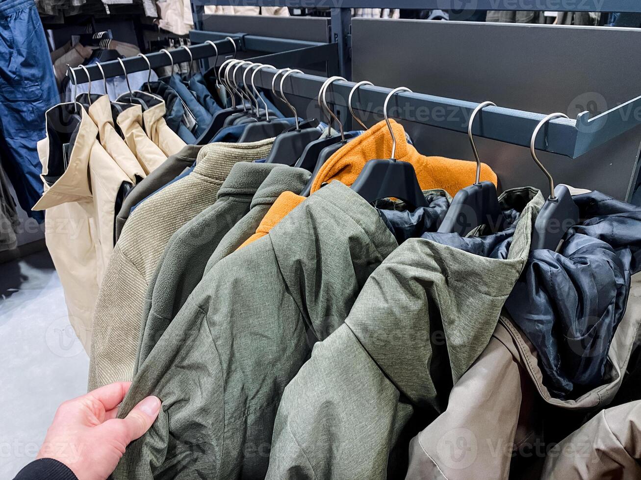 Explore the Stylish Collection of Casual Jackets displayed on Hangers in a Retail Store, showcasing a vibrant selection perfect for updating your wardrobe this season photo