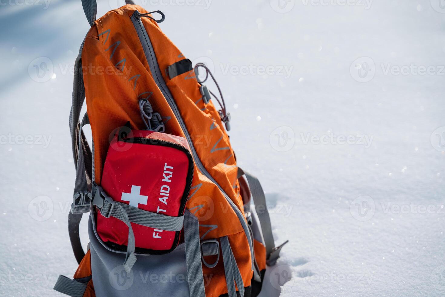 A backpack that contains a first aid kit is resting on the snowcovered ground, waiting to be used in case of any emergencies or injuries that may occur in the snowy surroundings photo