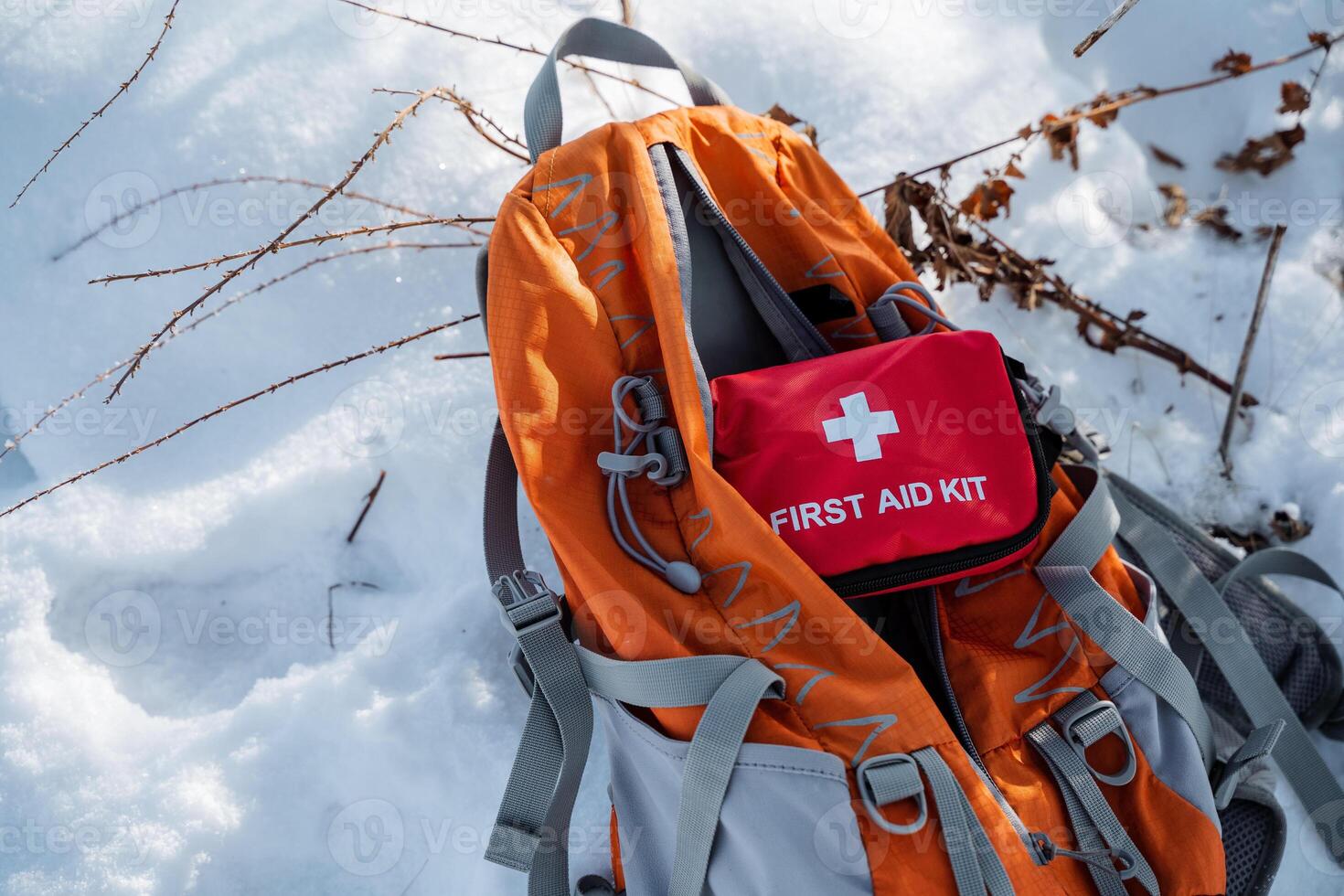 A reliable backpack with a stocked first aid kit is placed on the snow, ensuring quick access for emergencies during your outdoor adventures, regardless of conditions or challenges photo