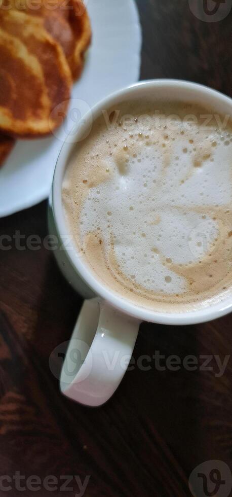 Cup of capuccino and pancakes photo