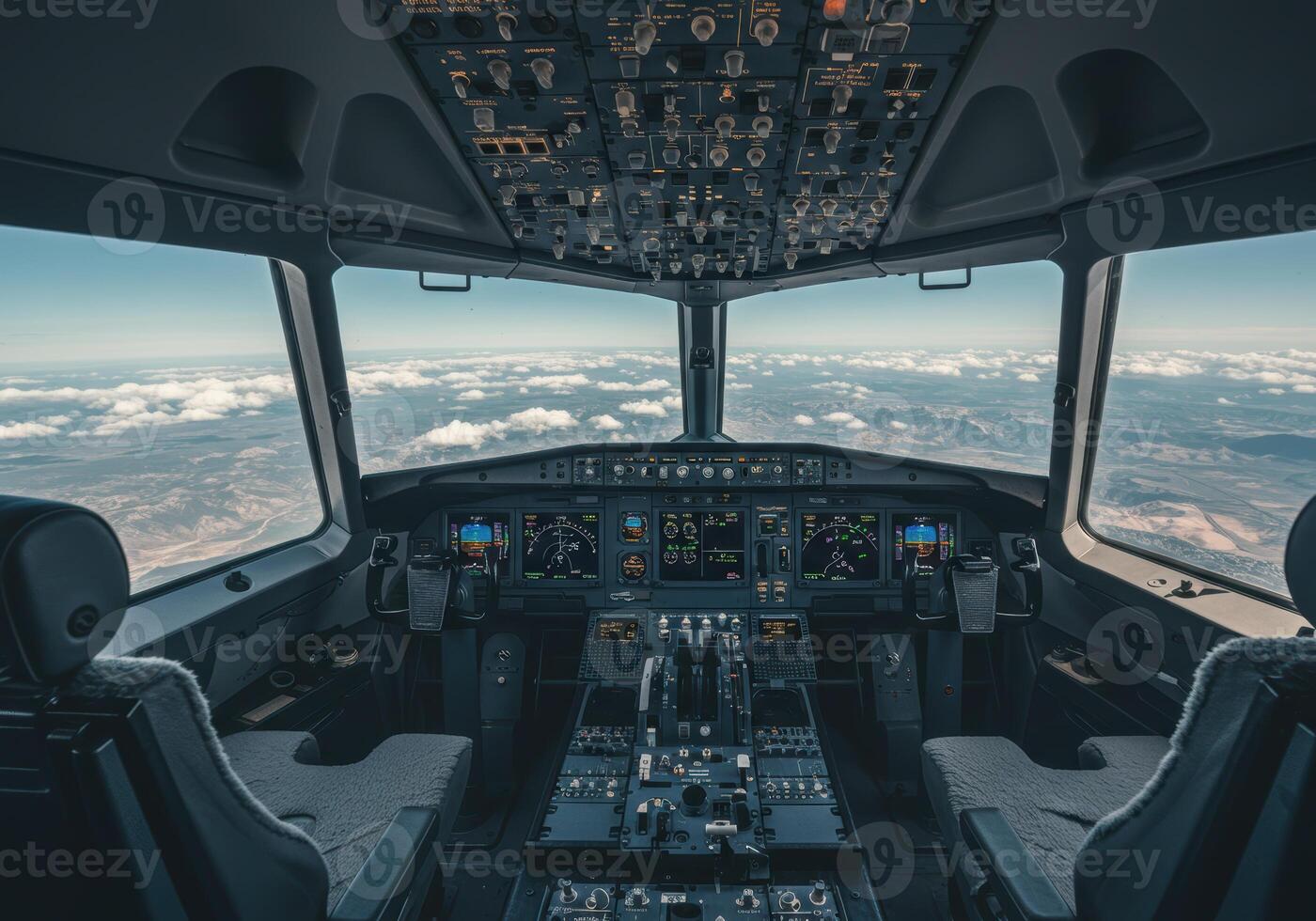 Inside a commercial aircraft cockpit, above the clouds, offering a scenic view from the flight deck. photo