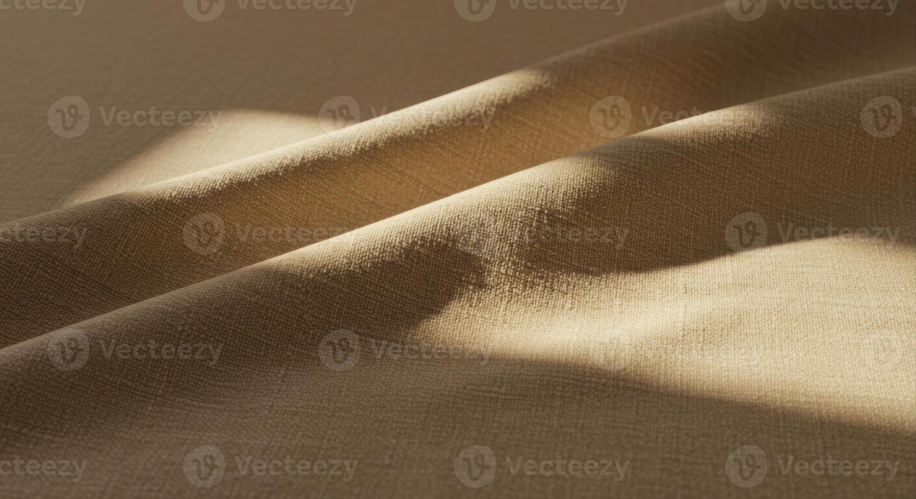 Beige fabric folds in gentle sunlight revealing subtle textures and organic patterns. photo