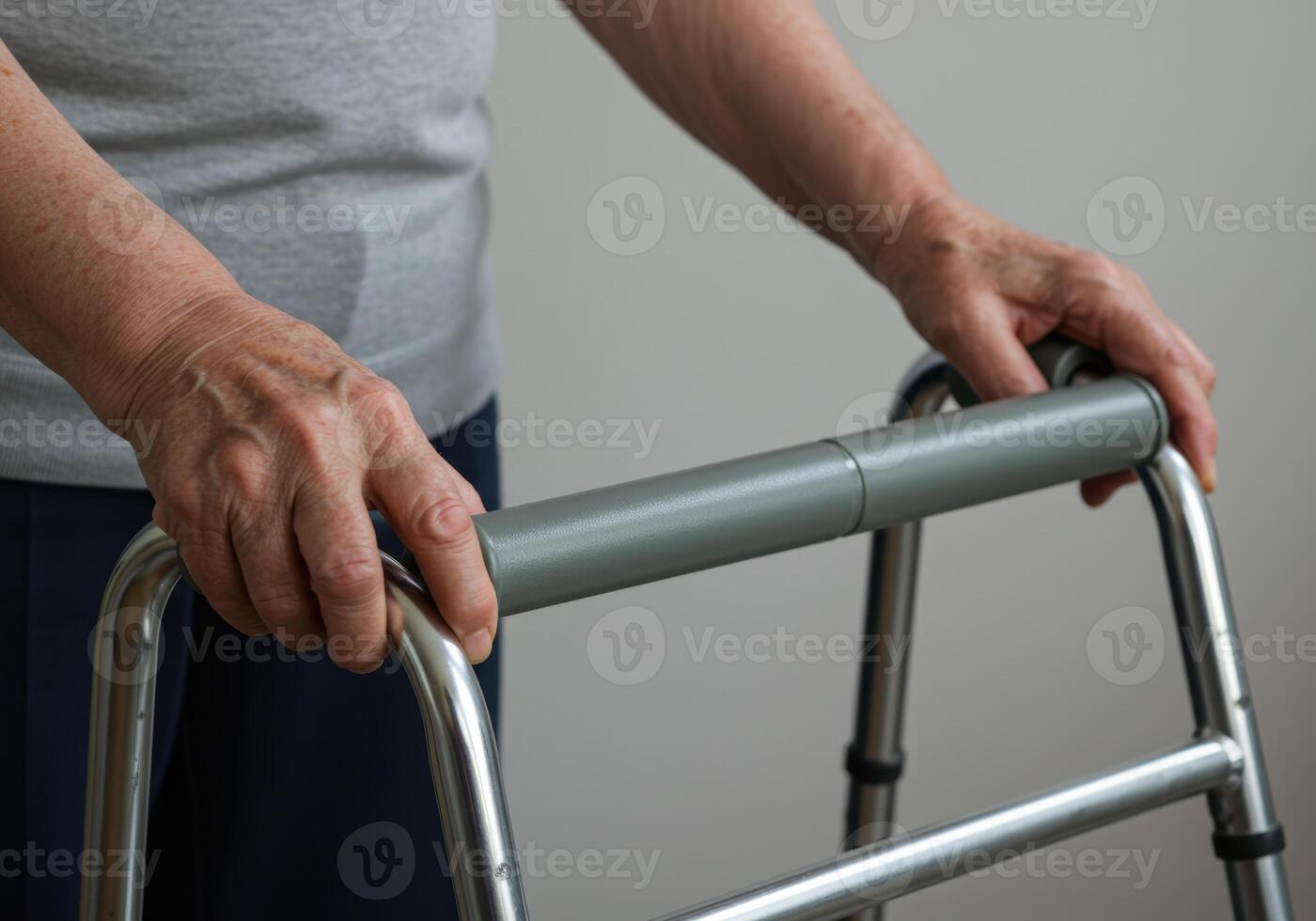 Close-up of a senior woman's hands holding onto a walker for support and mobility. photo
