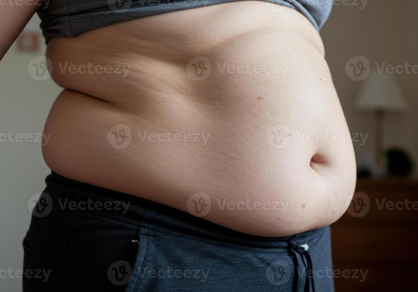 A close up of a person's side, highlighting their overweight abdomen and midsection. photo