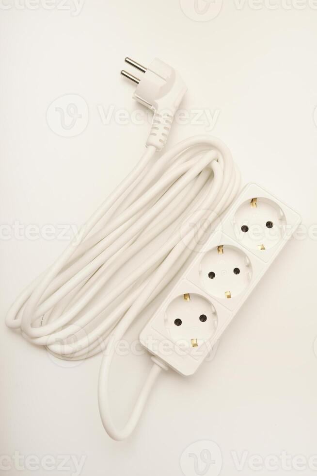 A three-way extension cable with a pearl-white wire and sockets on a white setting. photo