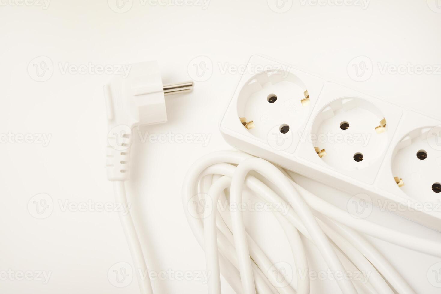 A white three-socket power cable with outlets on a neutral white base. photo