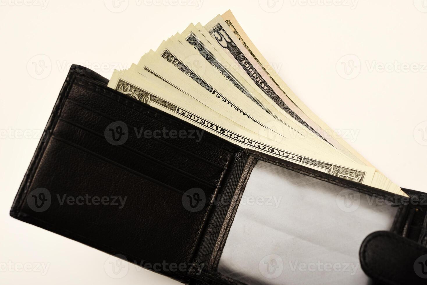 A dark wallet with a stack of banknotes displayed on a white canvas. photo