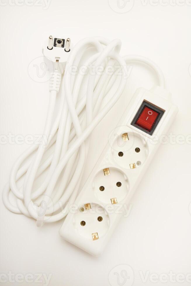 A multi-outlet extension cord with three white sockets and a matching wire on a white scene. photo