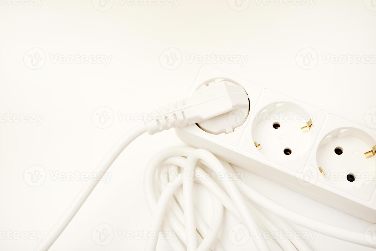 A three-plug electrical strip with a white cord showcased on an ivory-toned background. photo