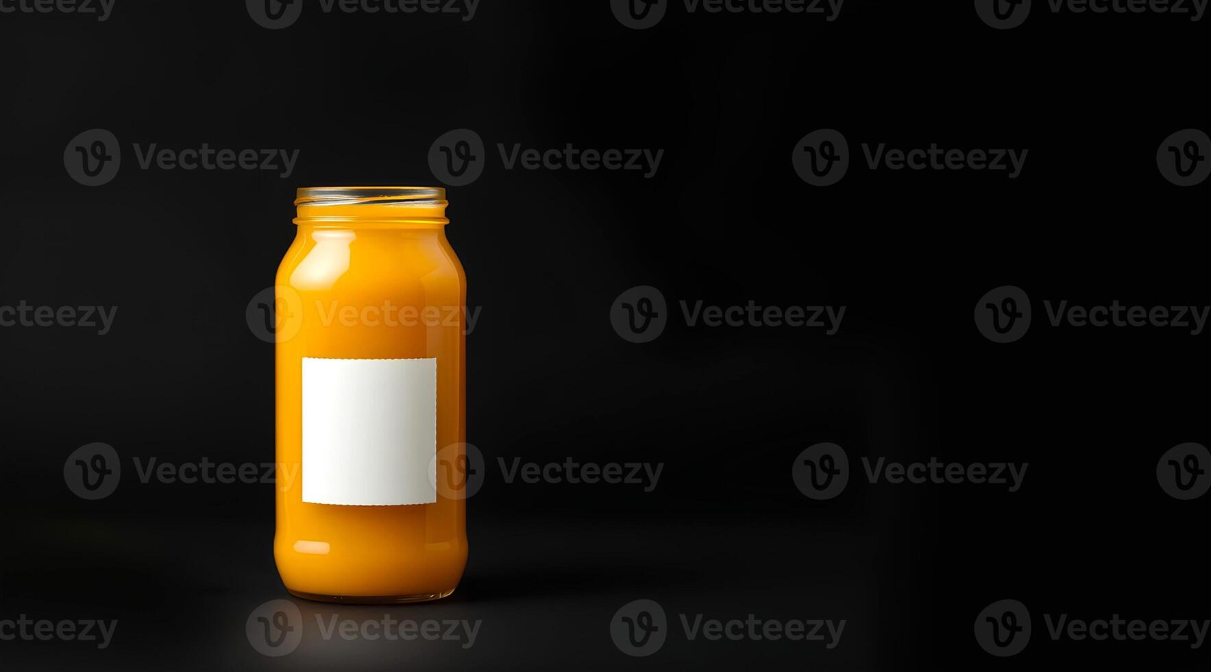 A jar of fresh mango juice and a blank white sticker label is attached on the jar on dark background photo