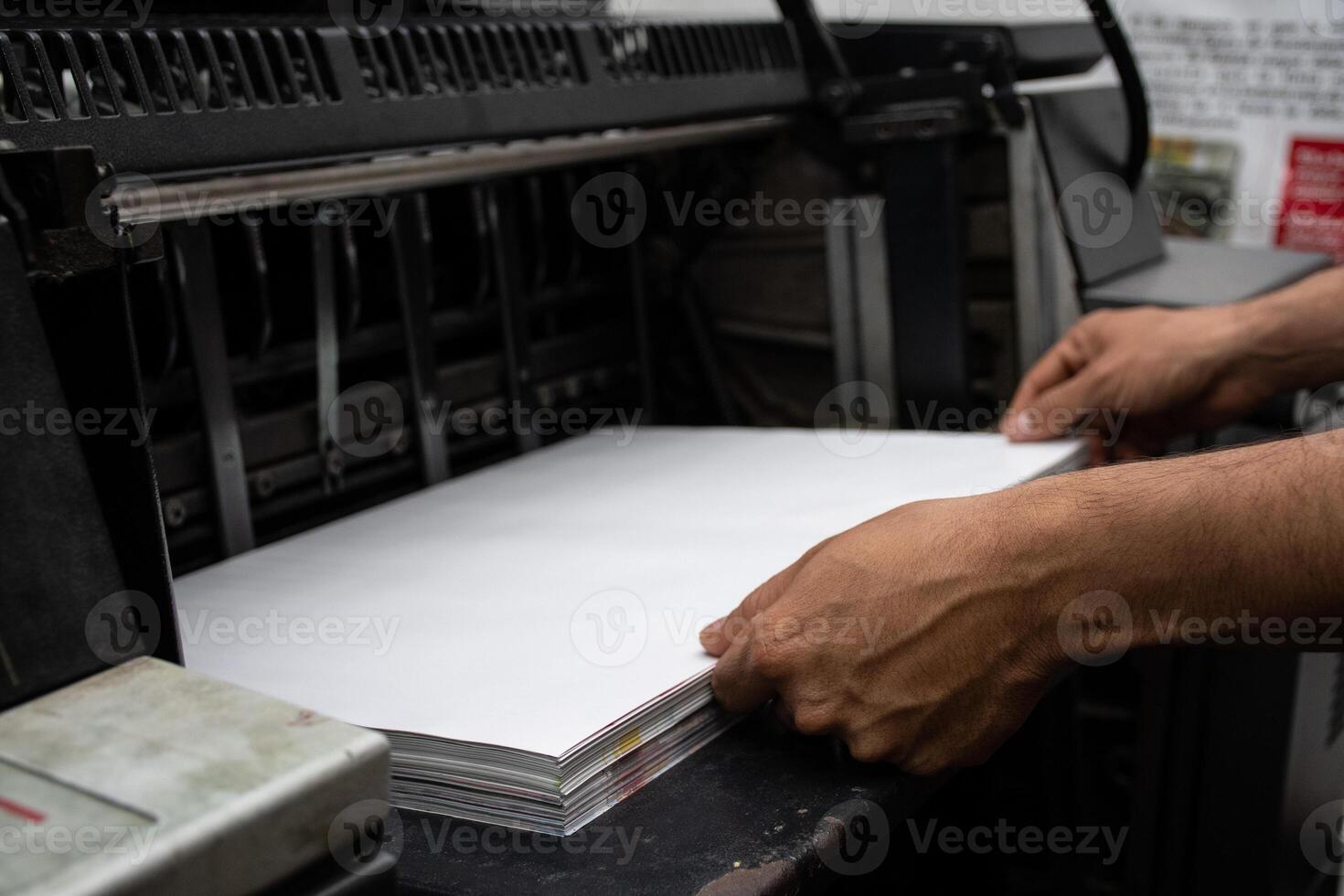 Operator Loading Paper into Industrial Printer Printing Process. High quality photo