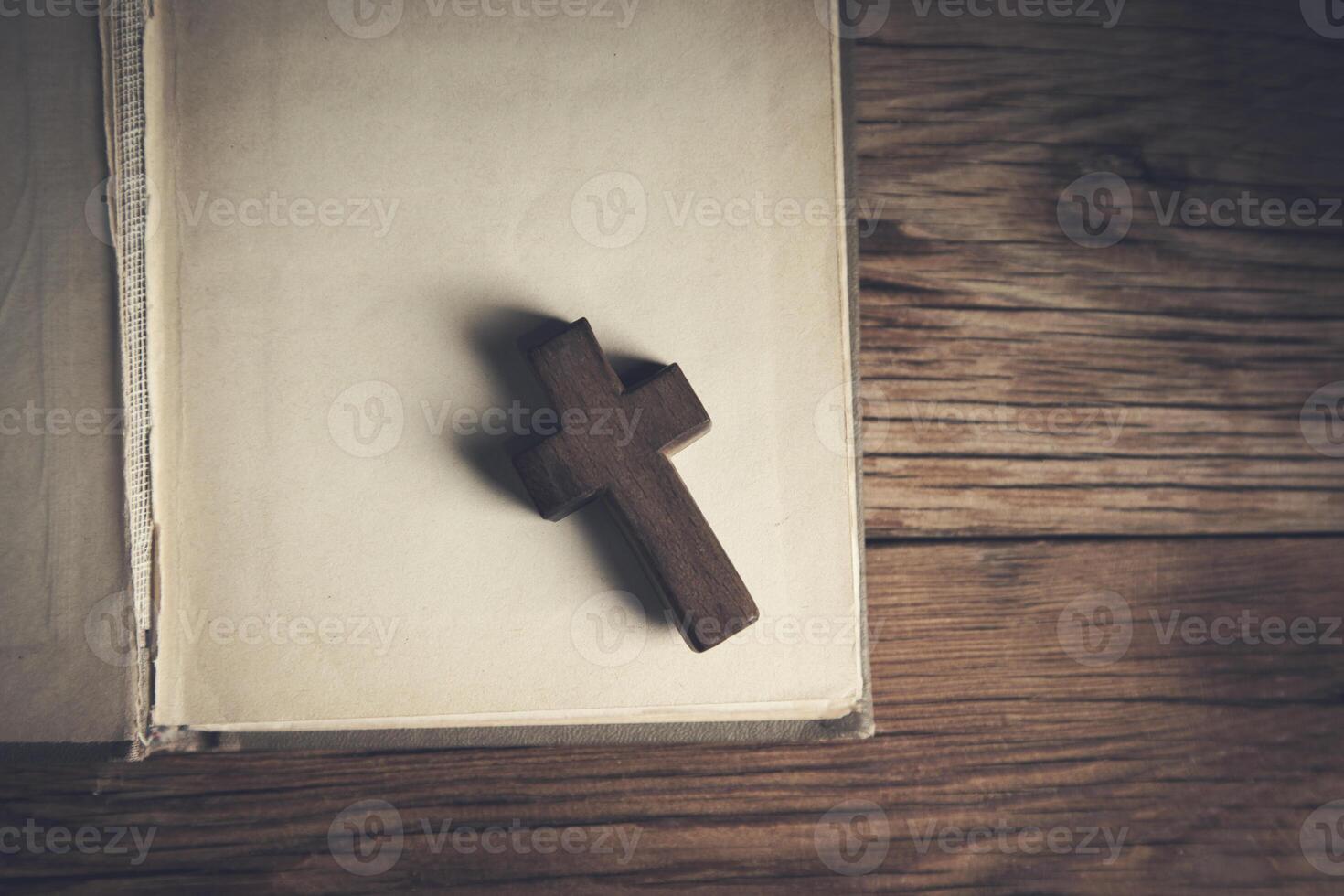 A wooden cross sits on top of an open book photo