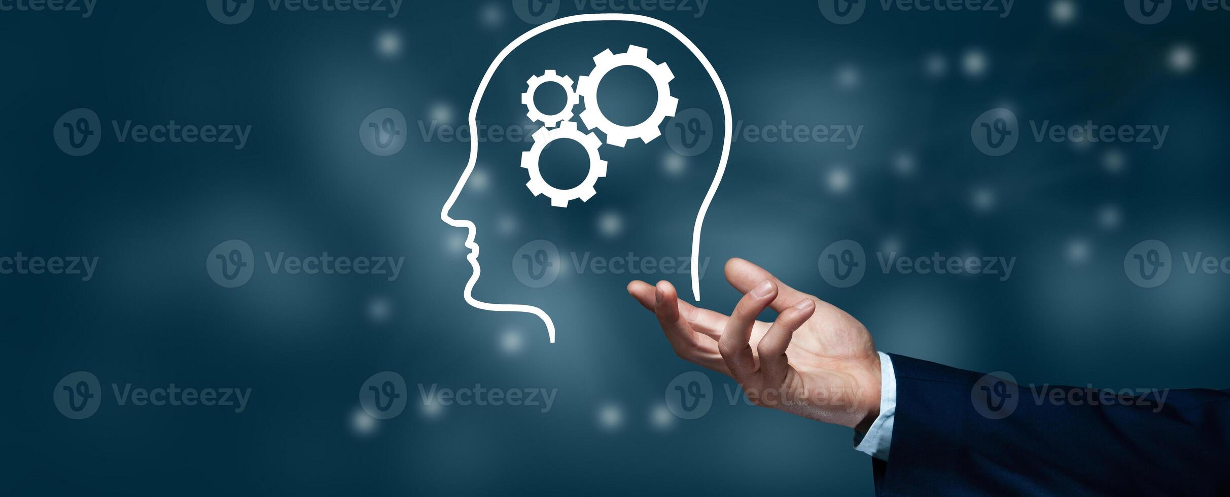 A hand is holding a brain with gears on it photo
