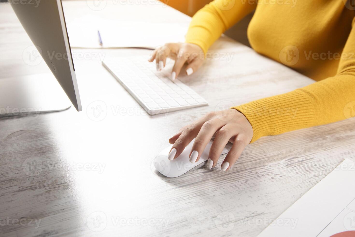A woman is typing on a computer keyboard photo