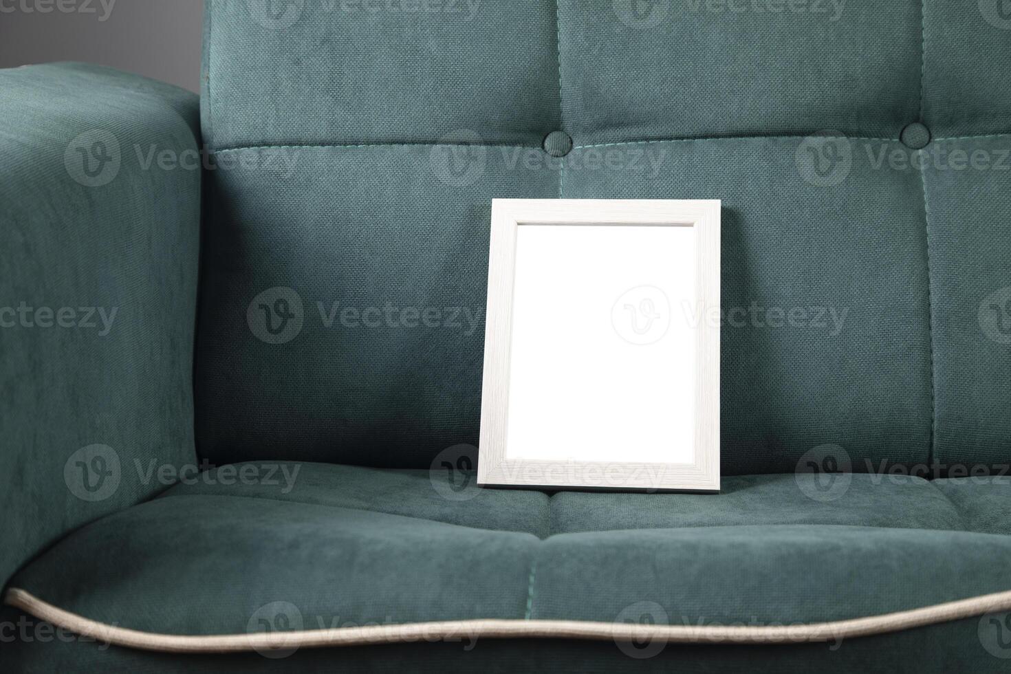 A white frame sitting on a green couch photo