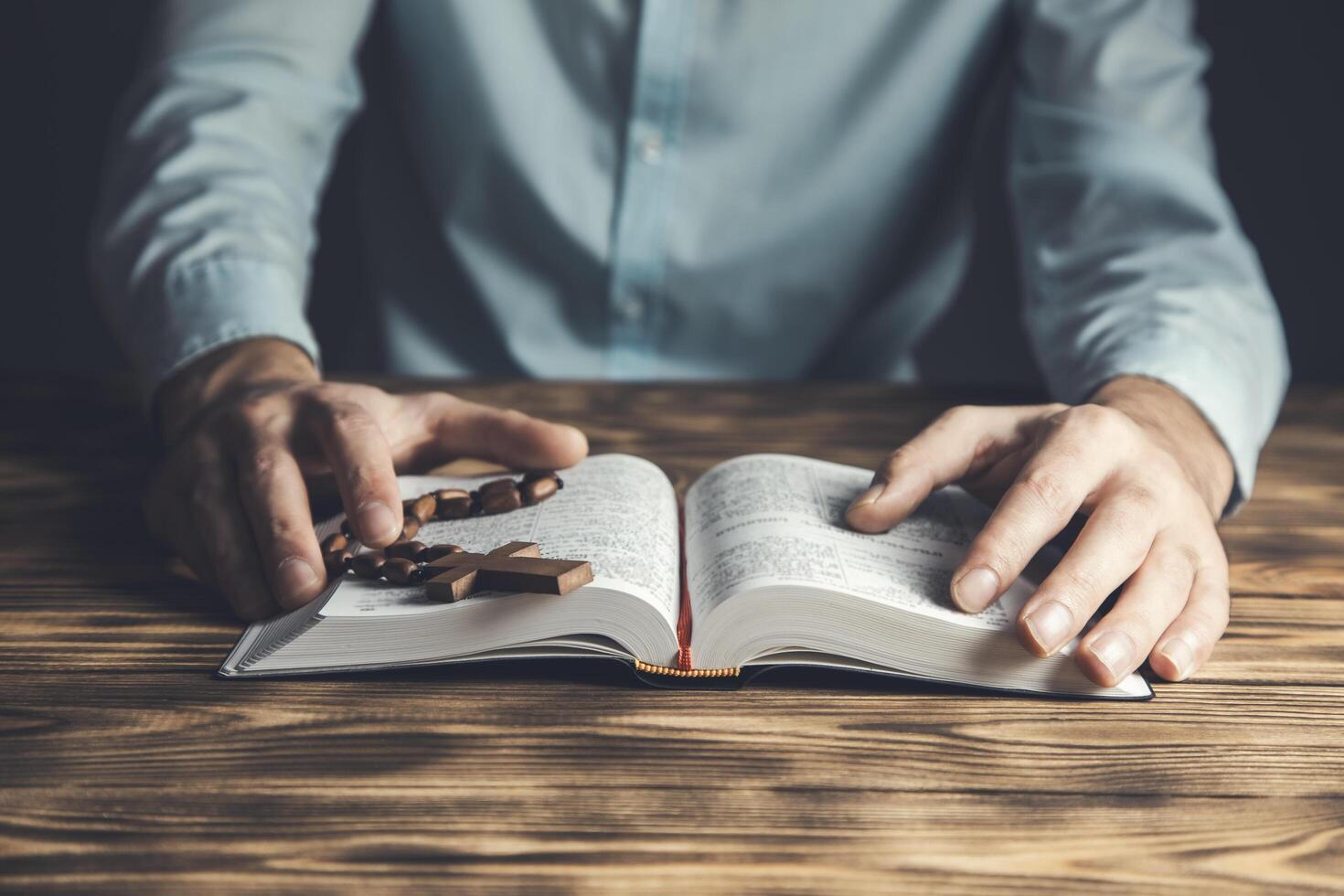 Man reading bible on wooden table photo