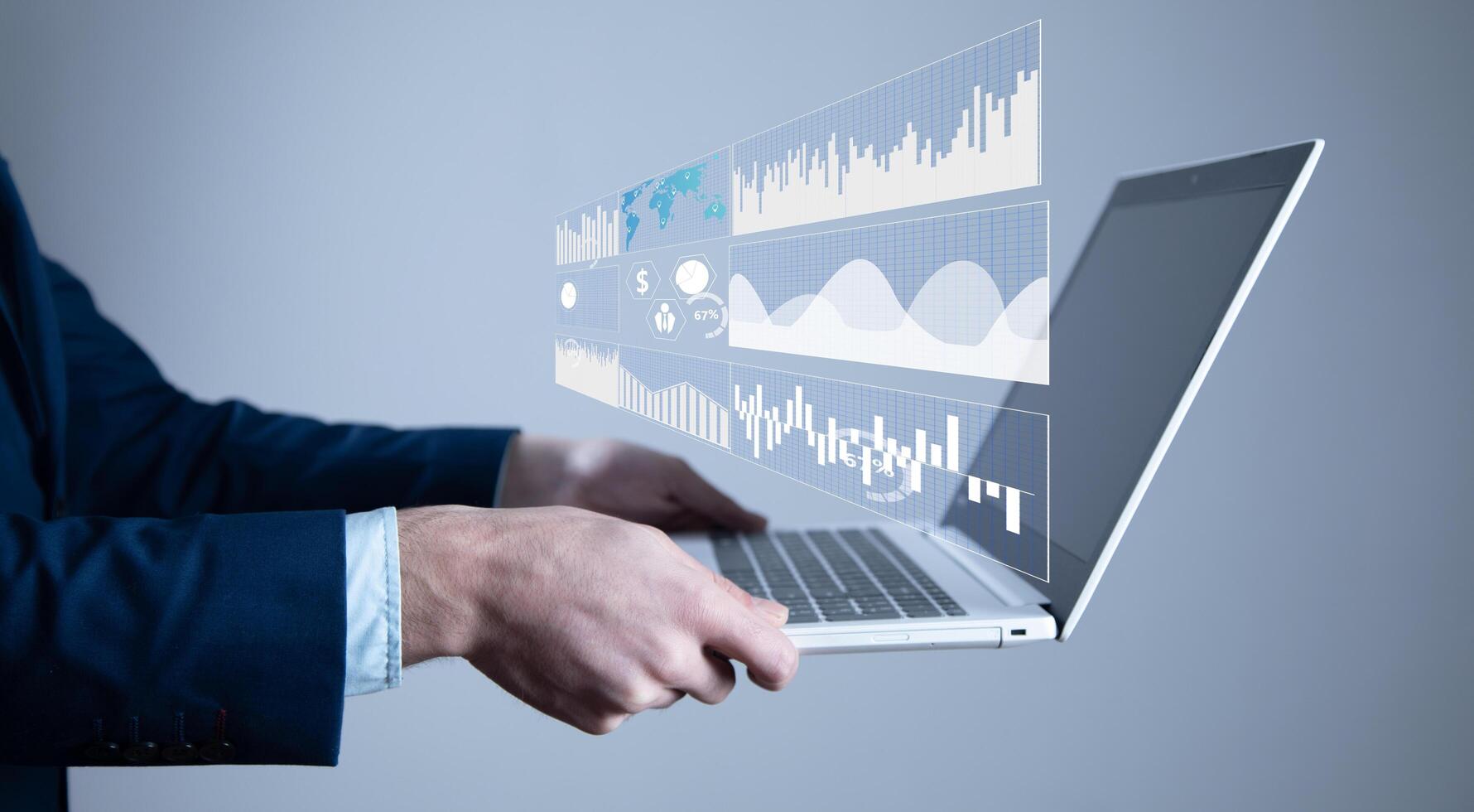 A person in a suit holding a laptop with graphs and charts photo