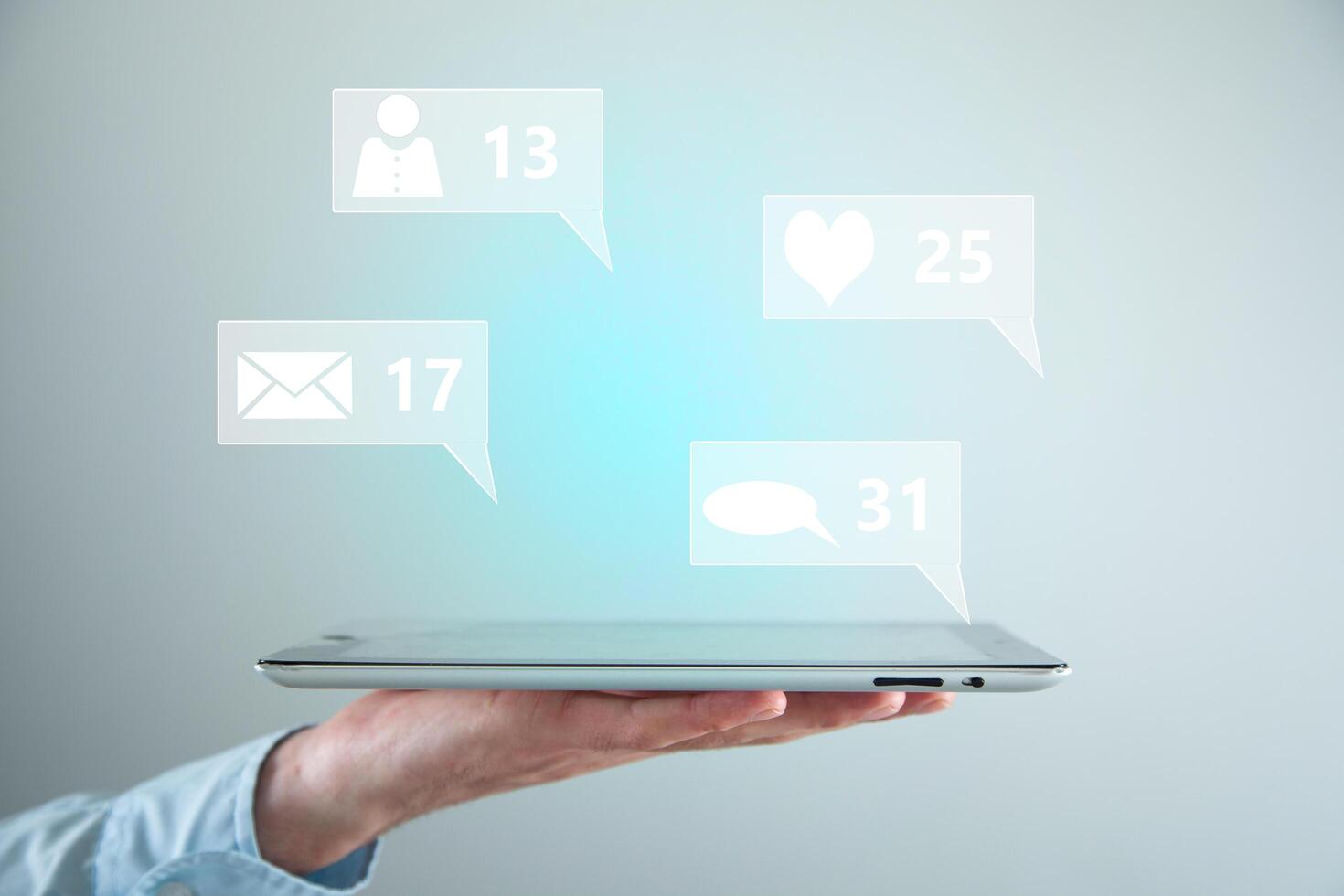 A person holding a tablet with social icons on it photo