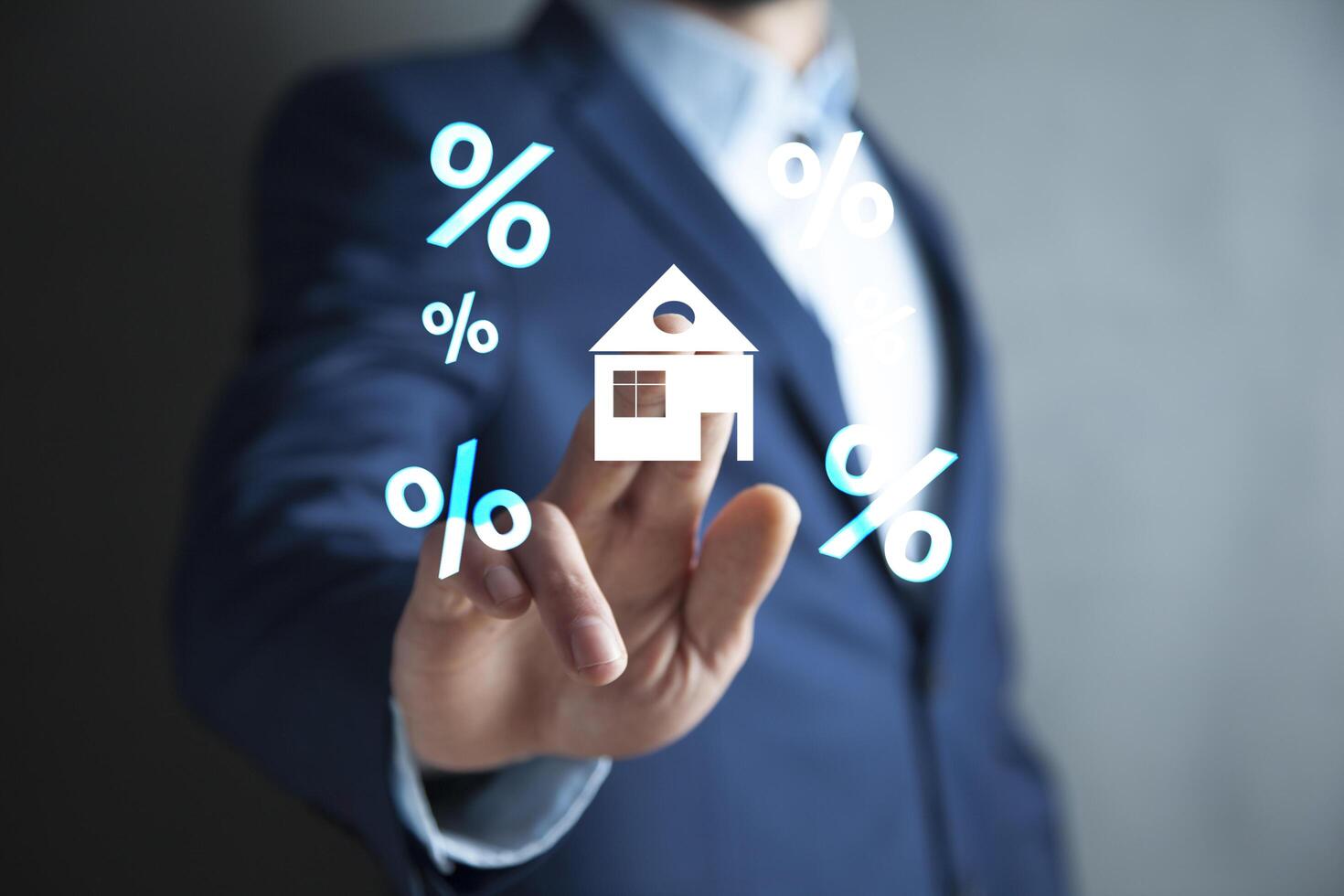 Man in suit holding house and percentage icons on his hand photo