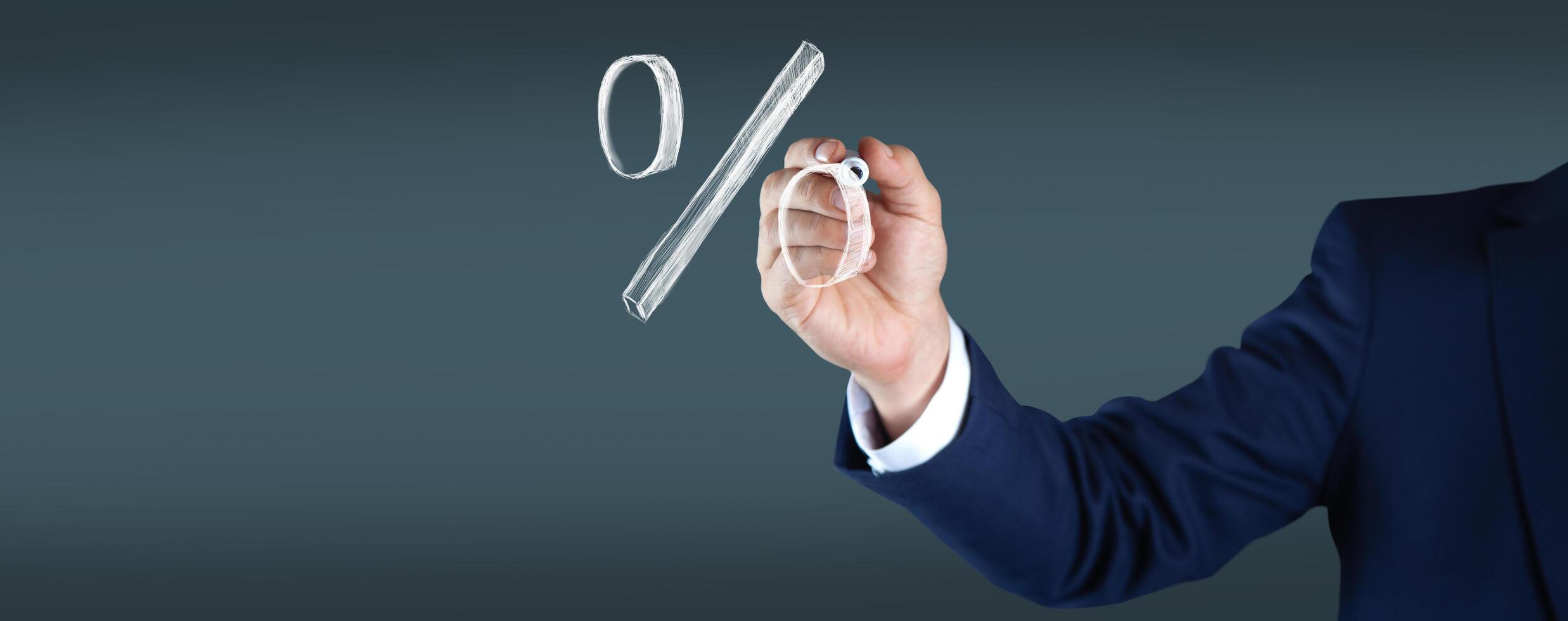 Businessman drawing percentage sign on transparent screen photo