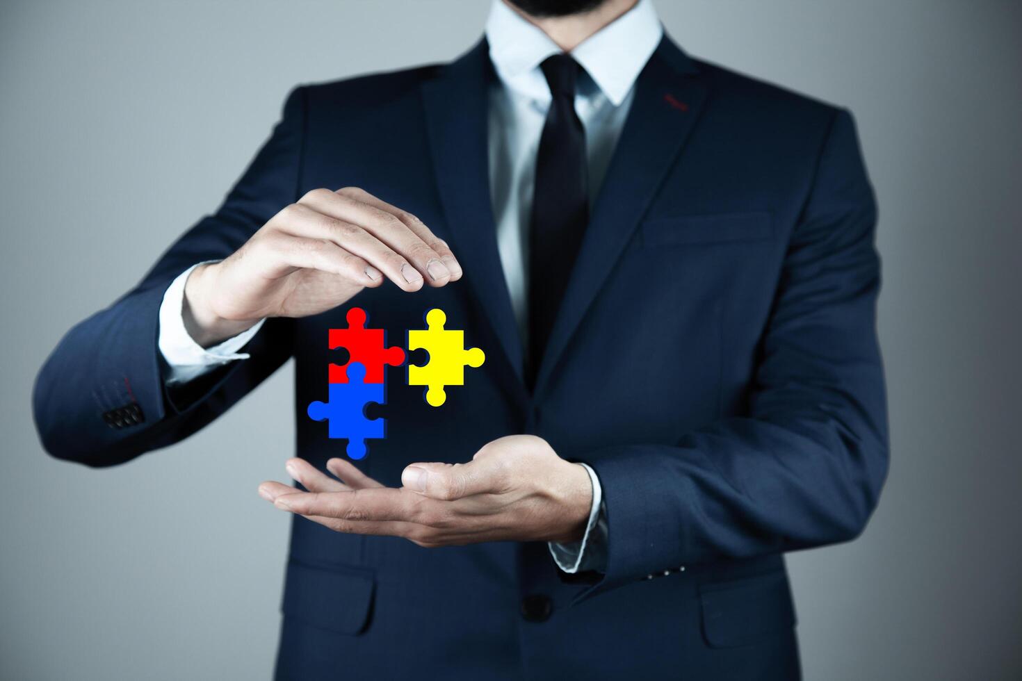 Businessman holding up puzzle pieces photo