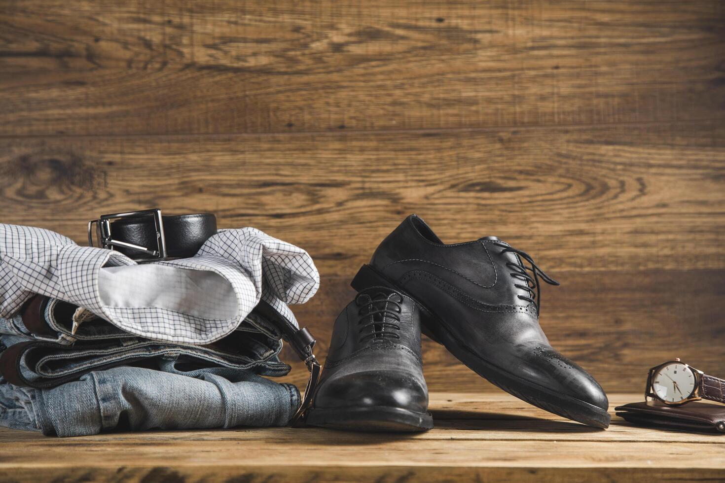 A pair of shoes, a watch, and a pair of jeans photo