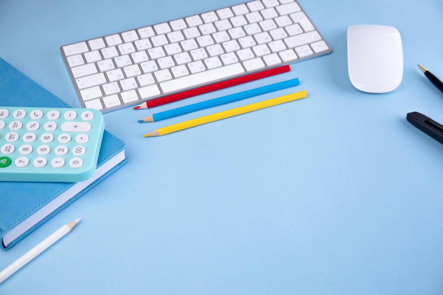 A desk with a calculator, pencils, and a mouse photo